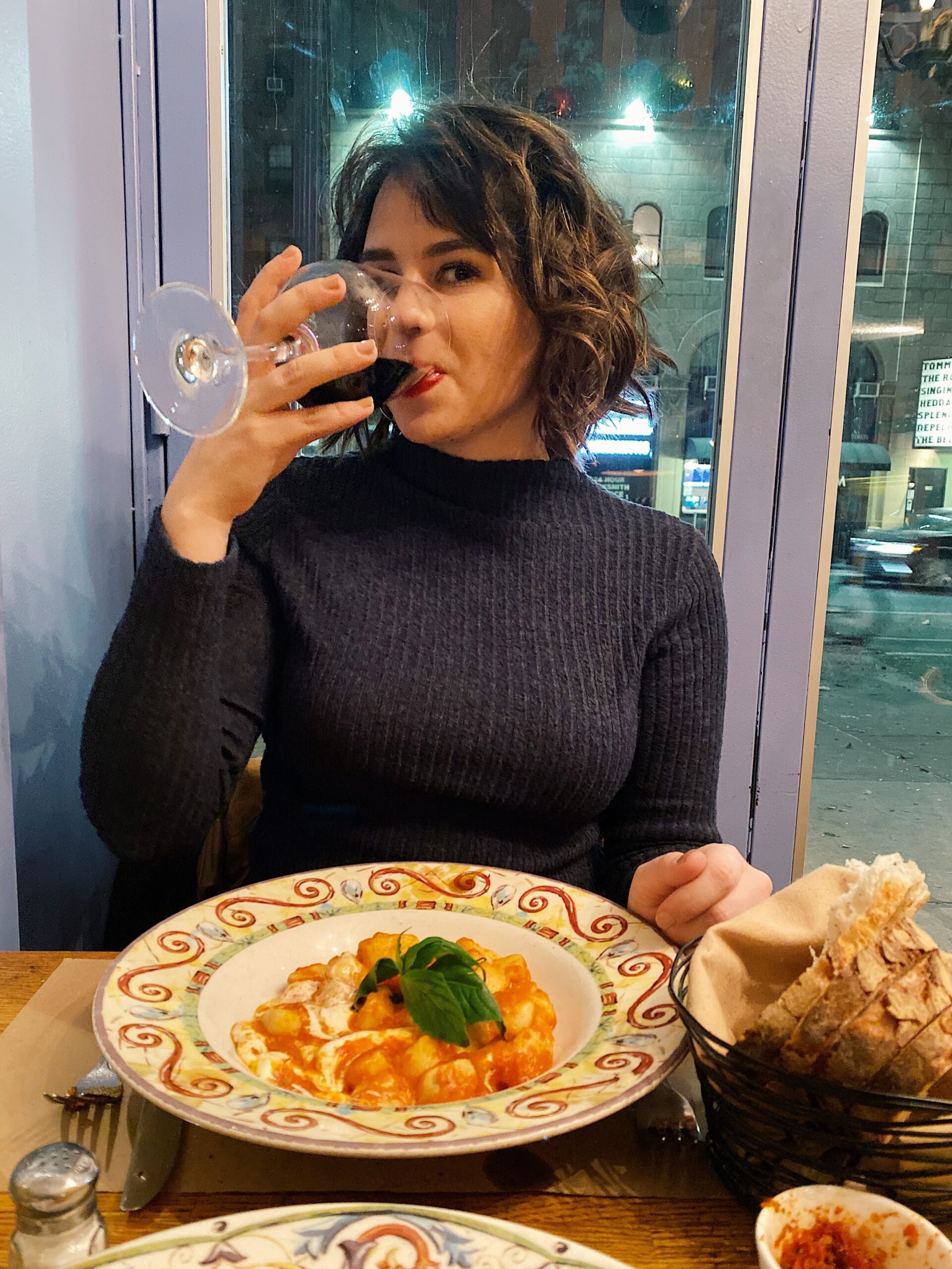 woman drinking wine with pasta - debt payoff journey