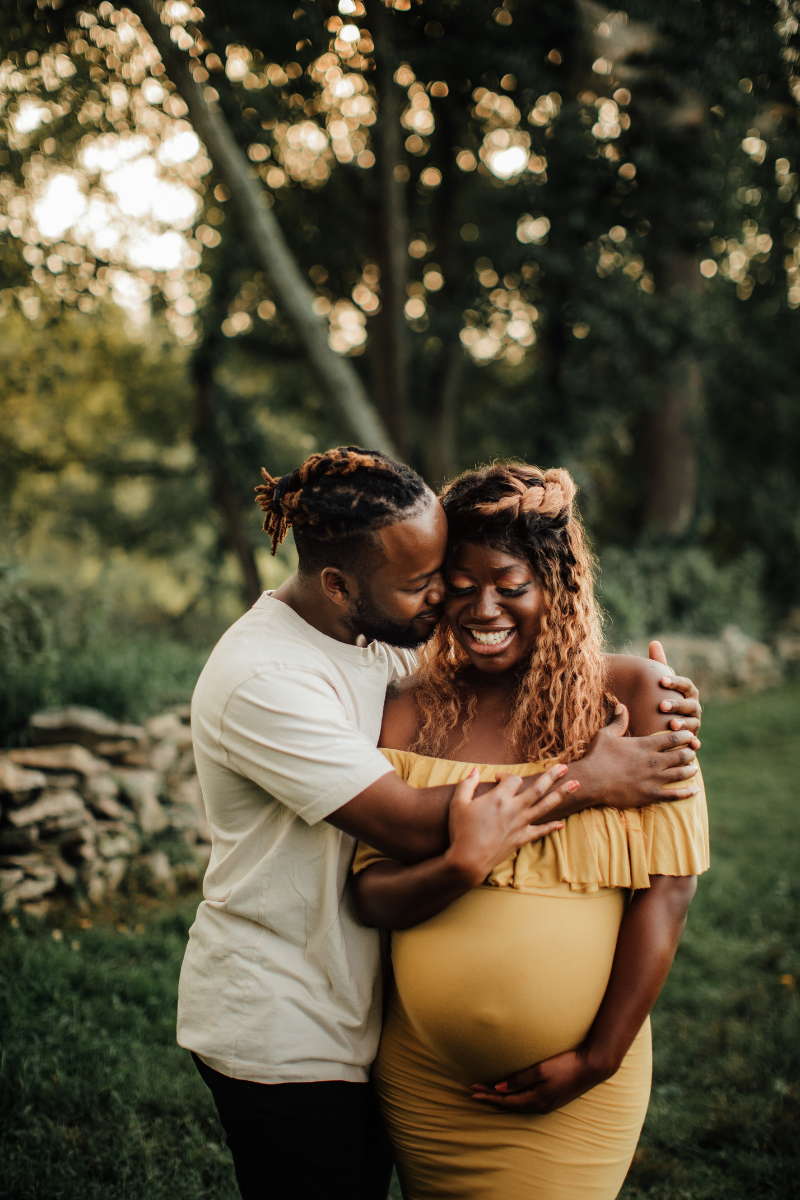 A pregnant couple hugging - how to talk about money with a spouse