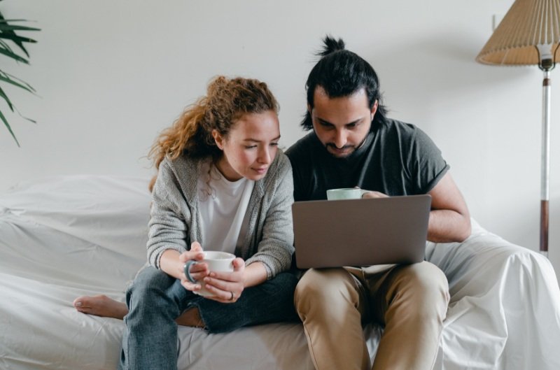Couple looking at a laptop - how to manage money in a marriage